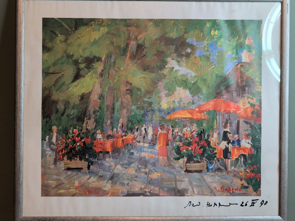 Sommerliches Straßencafé unter Bäumen mit roten Sonnenschirmen